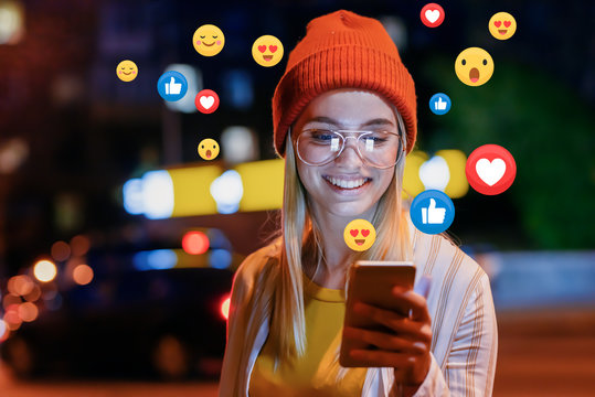 Creator smiling while using a phone with social media reaction icons